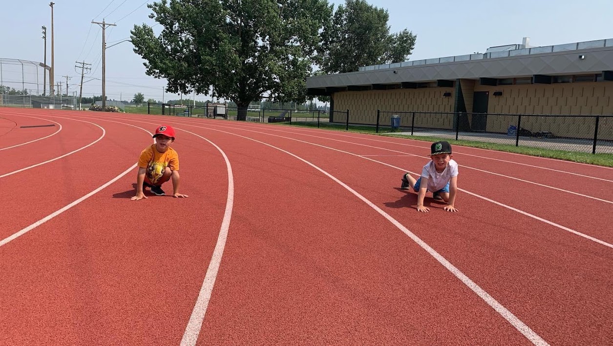 Kids in the ready position for a race at a track and field summer camp in Calgary.