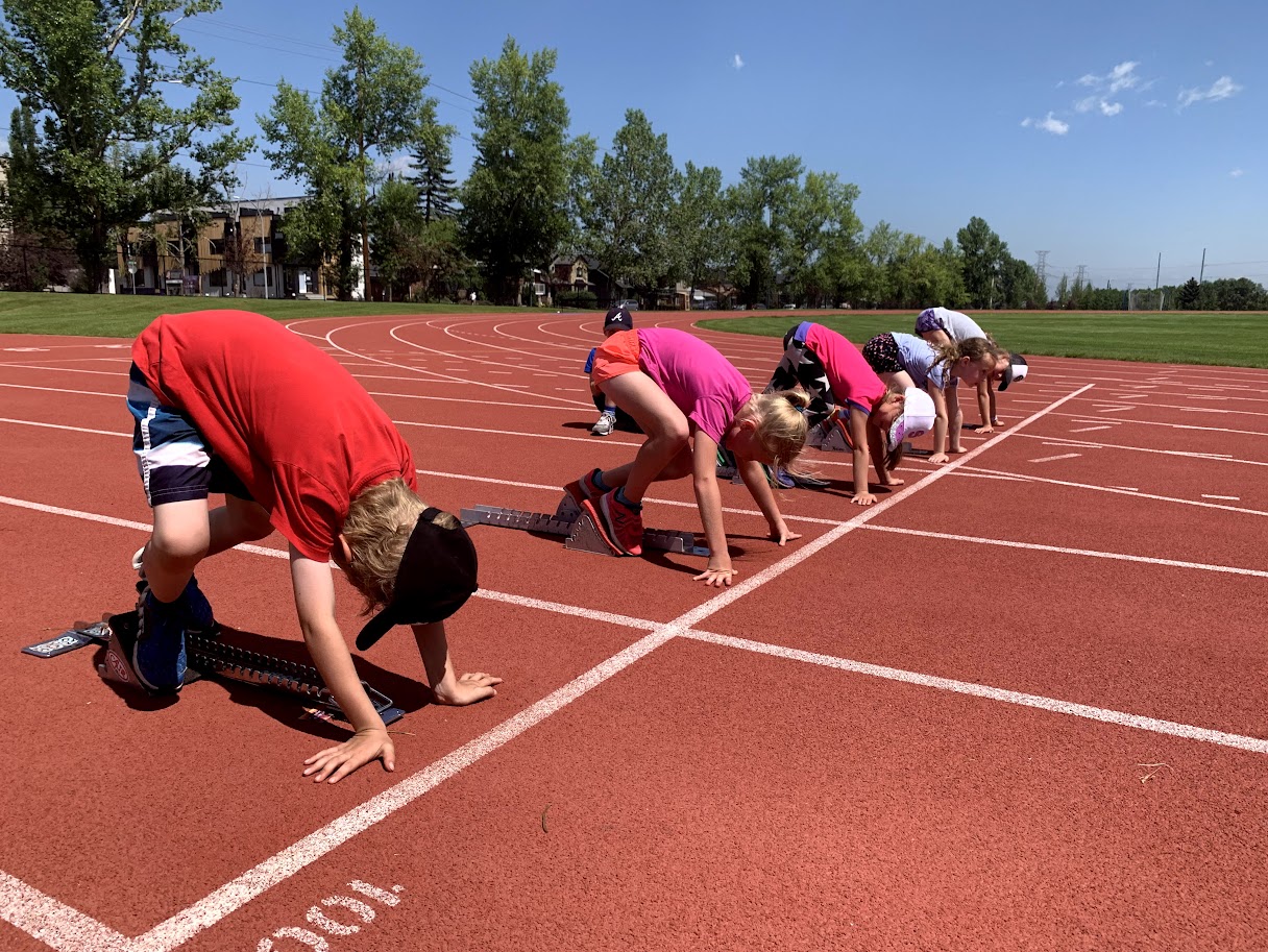 Kids in the ready position for a race at a track and field summer camp in Calgary.